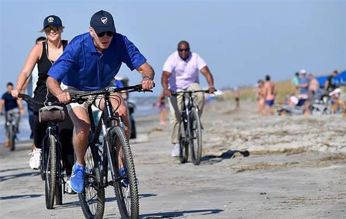بالفيديو ـ بايدن يستمتع بركوب الدراجة على شاطئ جزيرة كياوا..  ويفر من أسئلة الصحافيين عن ترامب 