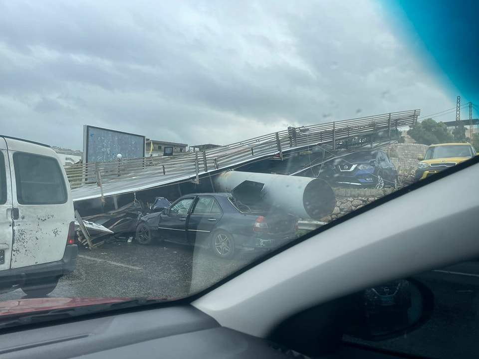 بالصور والفيديو - سقوط لوحة إعلانات كبيرة على معرض سيارات في الرميلة جنوبي لبنان 