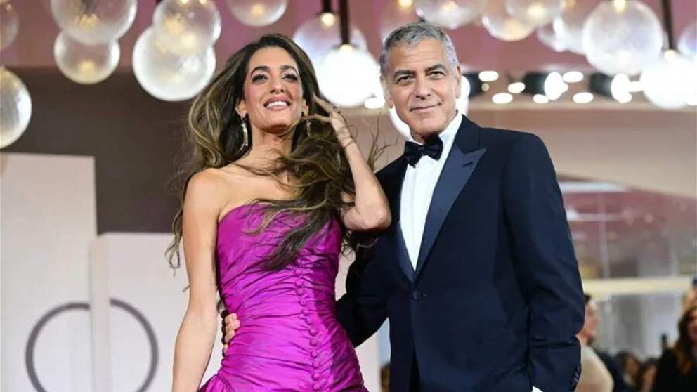 فستان أمل كلوني يطير على السجادة الحمراء.. وجورج كلوني يتدخل بطريقة مفاجئة!